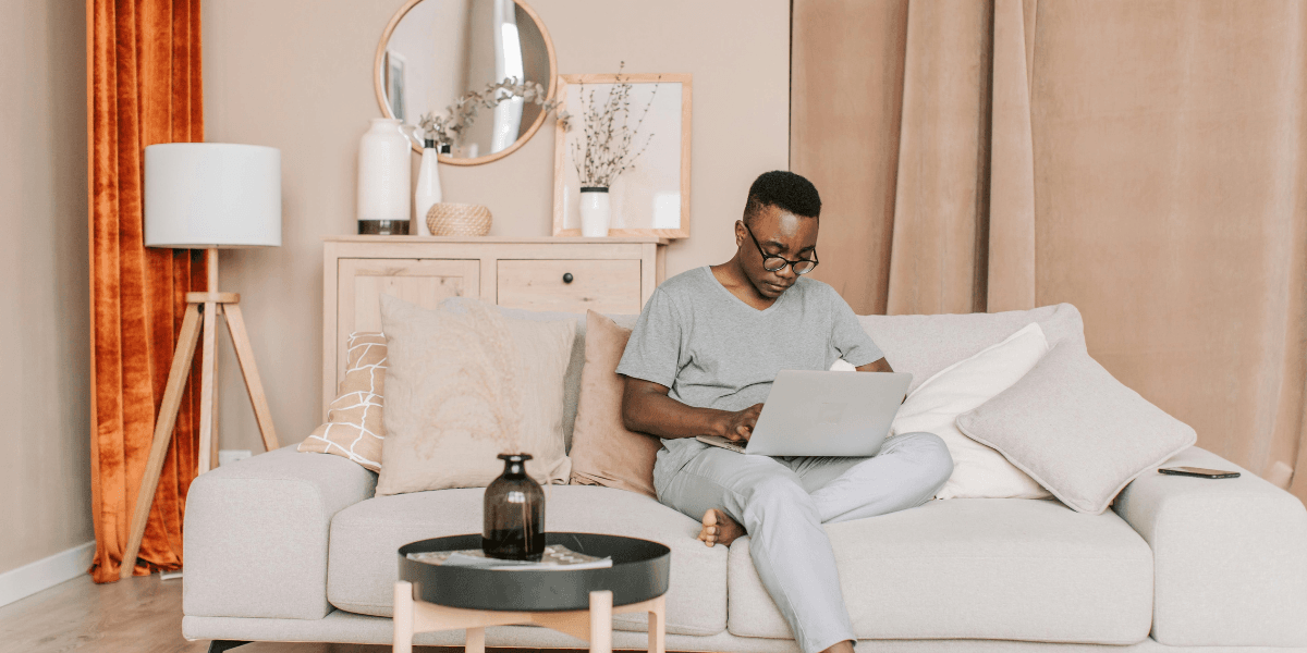Man sitting on sofa with laptop.png